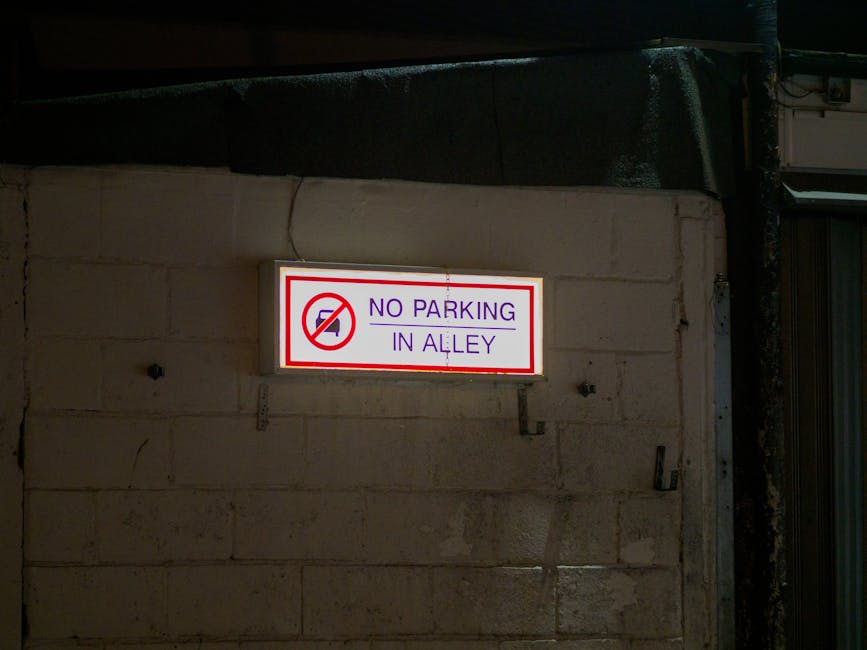 Inside an underground parking garage with a suspended overhead digital sign displaying parking restrictions in Spanish and Spanish translations, including speed limit of 10 km/h and maximum height of